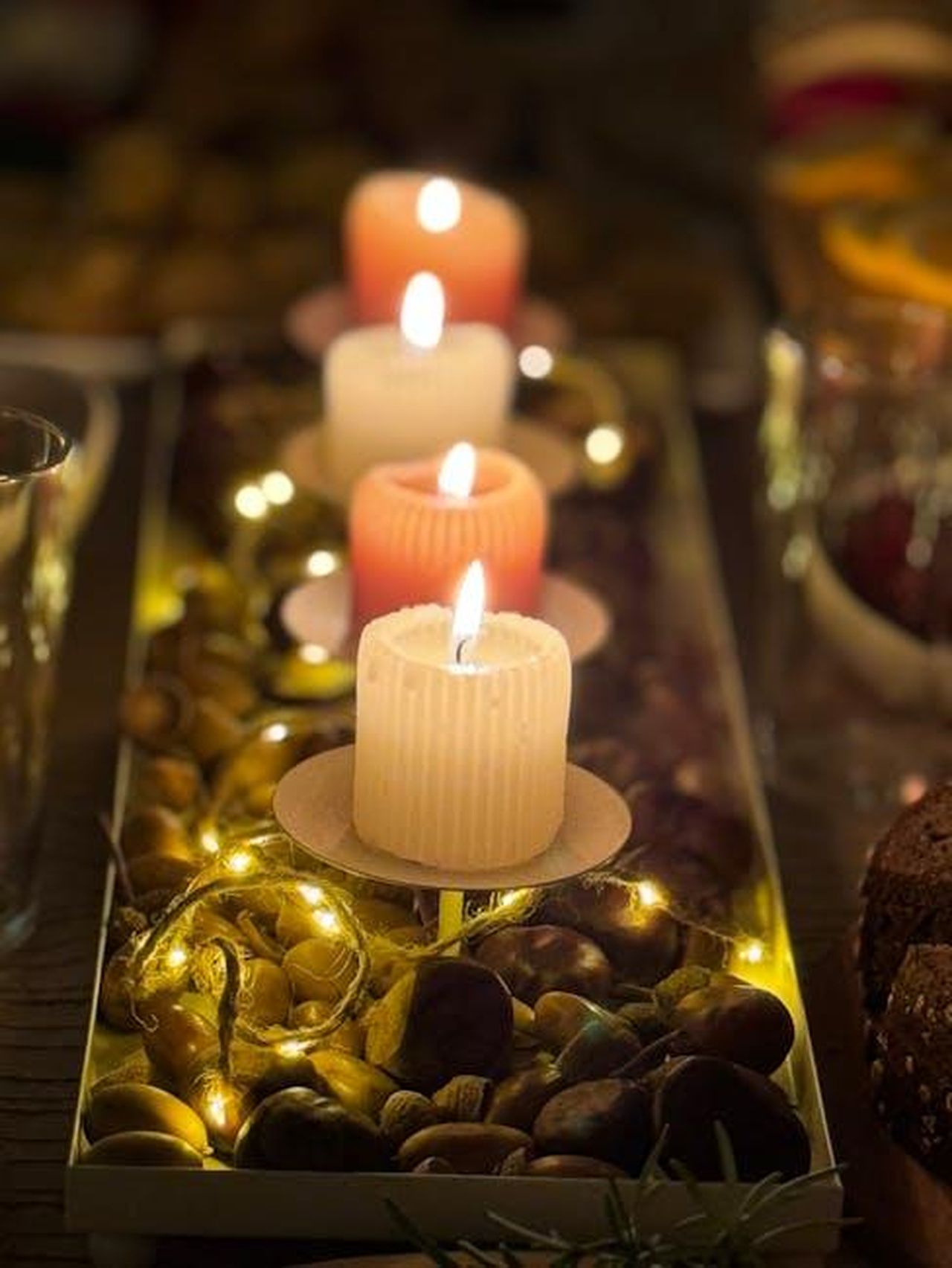 La_data_della_cena_rubata_dal_coniglio_di_Pasqua_3sqARBcPR8 - Confidenze24 Source: Vadim Malitskii - pexels - Four glowing candles with a rustic centerpiece create a cozy ambiance.