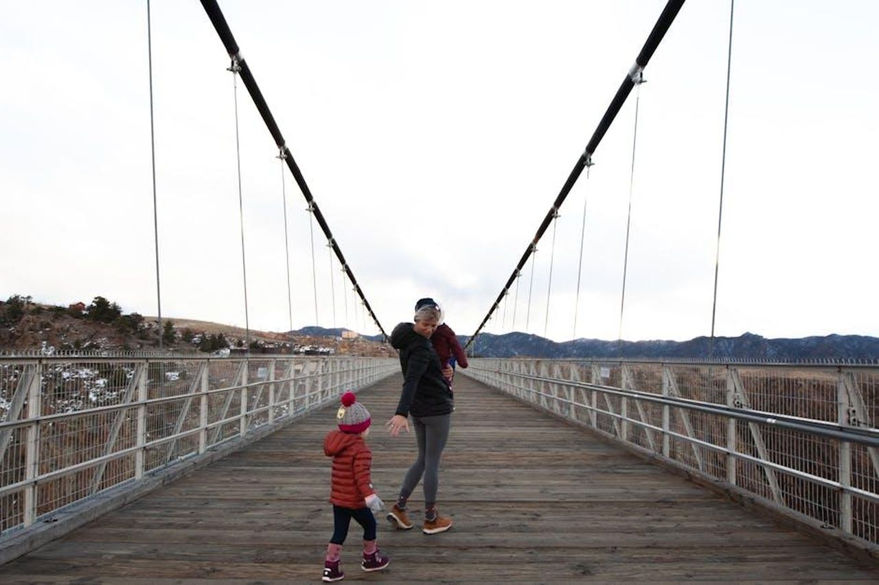 La_discrezione_della_famiglia_reale_3VGrEp3btM - Confidenze24 Source: Josh Willink - pexels - Mother with children on a scenic suspension bridge in a winter landscape.