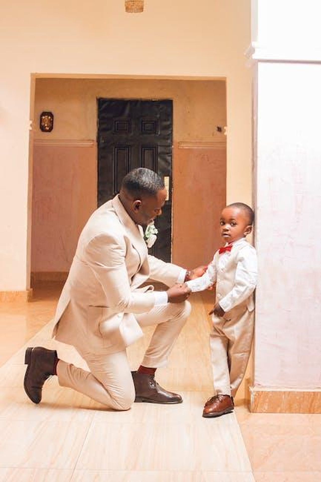 La_frustrazione_di_Rebecca_per_la_situazione_attuale_SPKQeX6d6K - Confidenze24 Source: Chidi Young - pexels - A father and son share a heartfelt moment in matching attire during a wedding ceremony indoors.