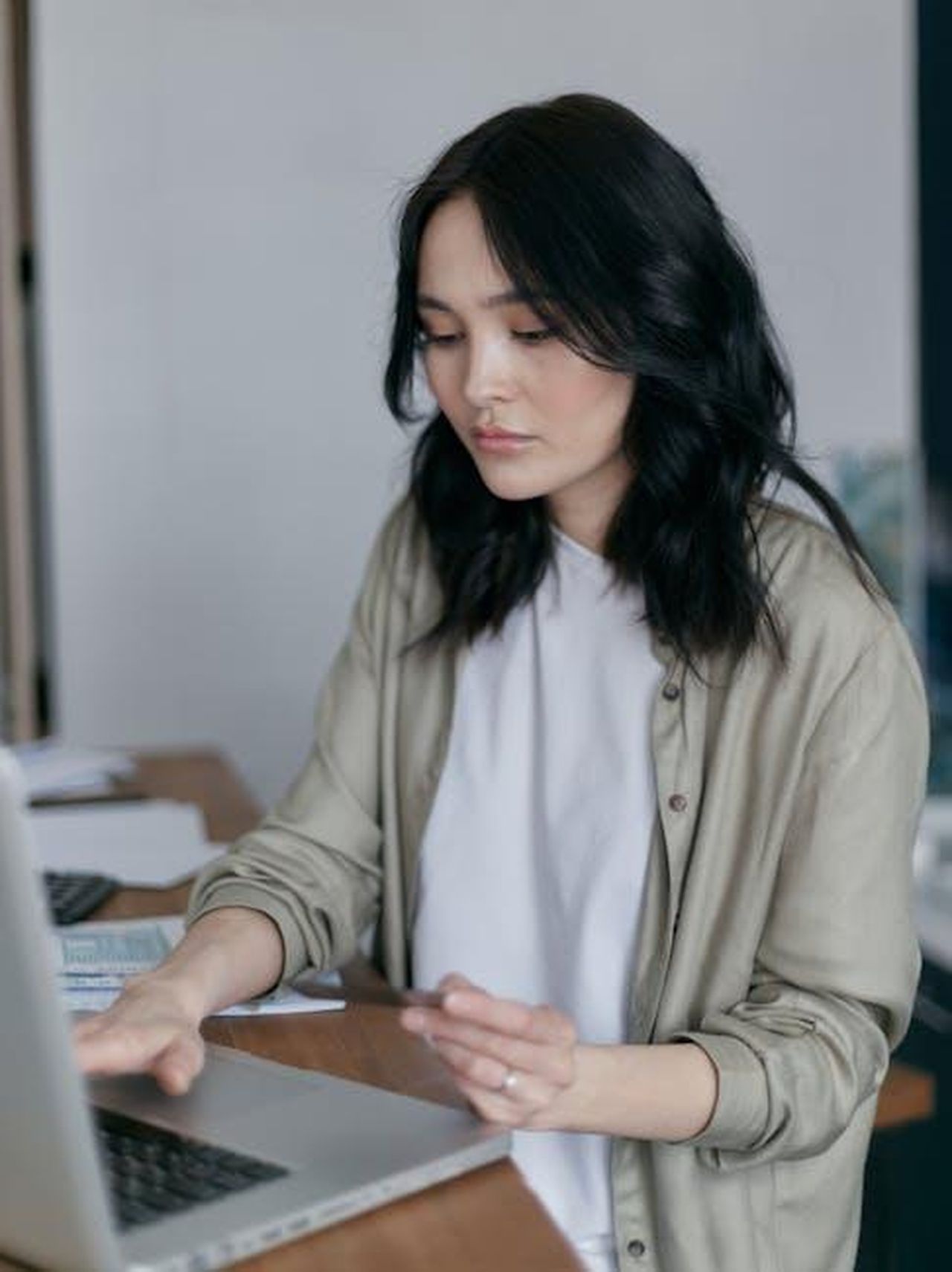 Le_critiche_alla_gestione_di_Chandauka_kDOTuKvp7H - Confidenze24 Source: Mikhail Nilov - pexels - Focused young woman working on a laptop at her desk, managing finances.