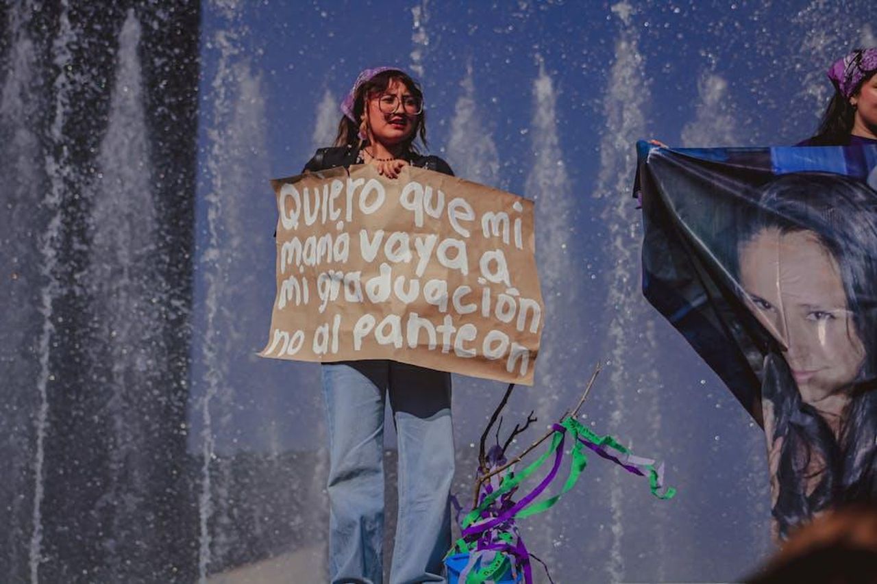 Le_dichiarazioni_di_Kanye_sulla_libert_di_espressione_ZwougAxiLM - Confidenze24 Source: Torrans Mayorquin - pexels - A woman holds a sign during a public protest, advocating for a social cause. Background features a water fountain.