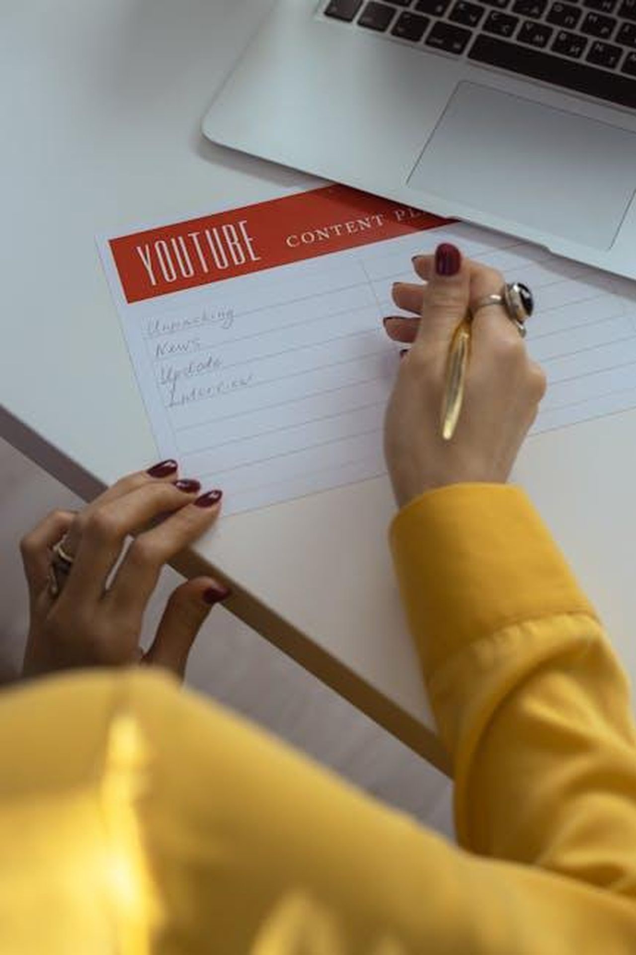 Le_reazioni_al_tweet_di_Kanye_VQTpbQIane - Confidenze24 Source: cottonbro studio - pexels - Woman with manicured nails writes YouTube content ideas in office setting.