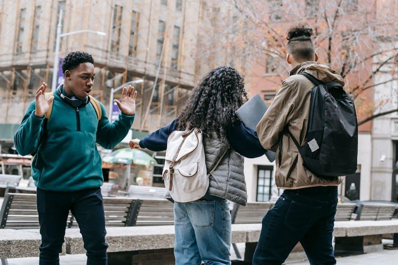 Le_reazioni_alle_dichiarazioni_di_Chappell_Roan_bJth5XDIk3 - Confidenze24 Source: Keira Burton - pexels - Back view of faceless student with backpack pushing away diverse classmates while standing in city park