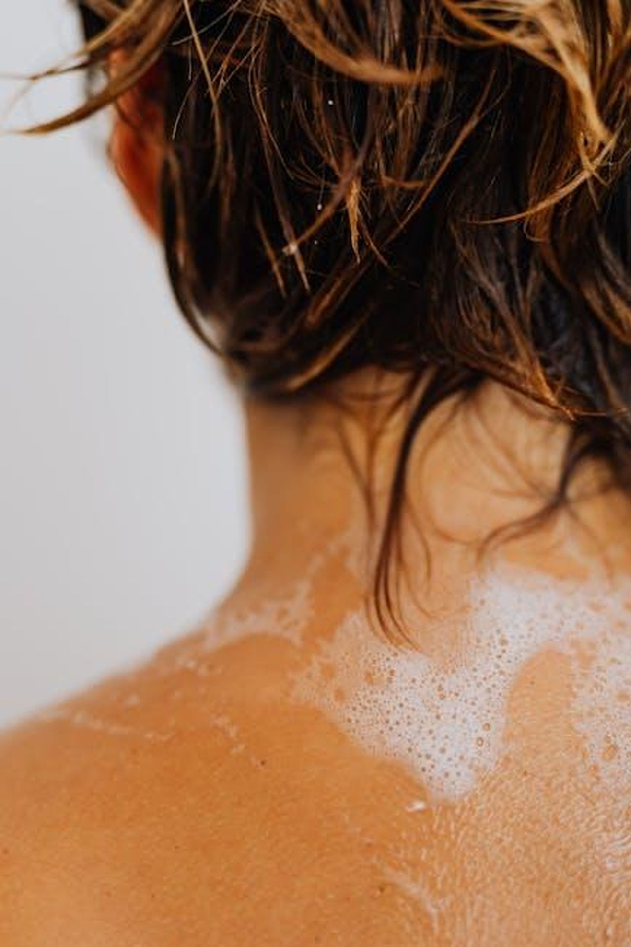 Offerte_e_promozioni_di_Bath__Body_Works_1VWPxx0yFl - Confidenze24 Source: Photo By: Kaboompics.com - pexels - Detailed shot of wet hair with soapy water on a back, highlighting cleansing routine.