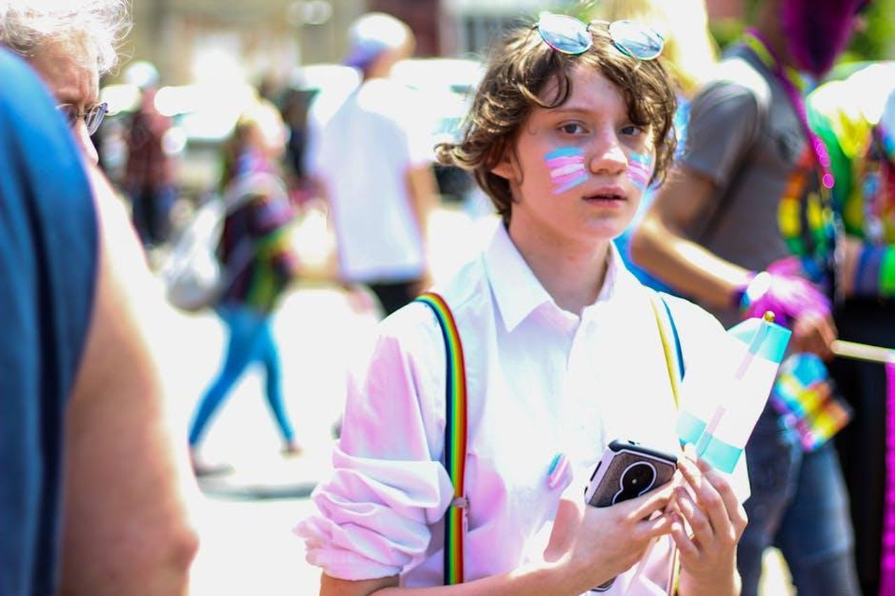 Proteggere_il_tuo_attivista_5ZJpUTCoBs - Confidenze24 Source: Rosemary Ketchum - pexels - Young person with face paint and a flag participates in a vibrant LGBTQ pride parade.