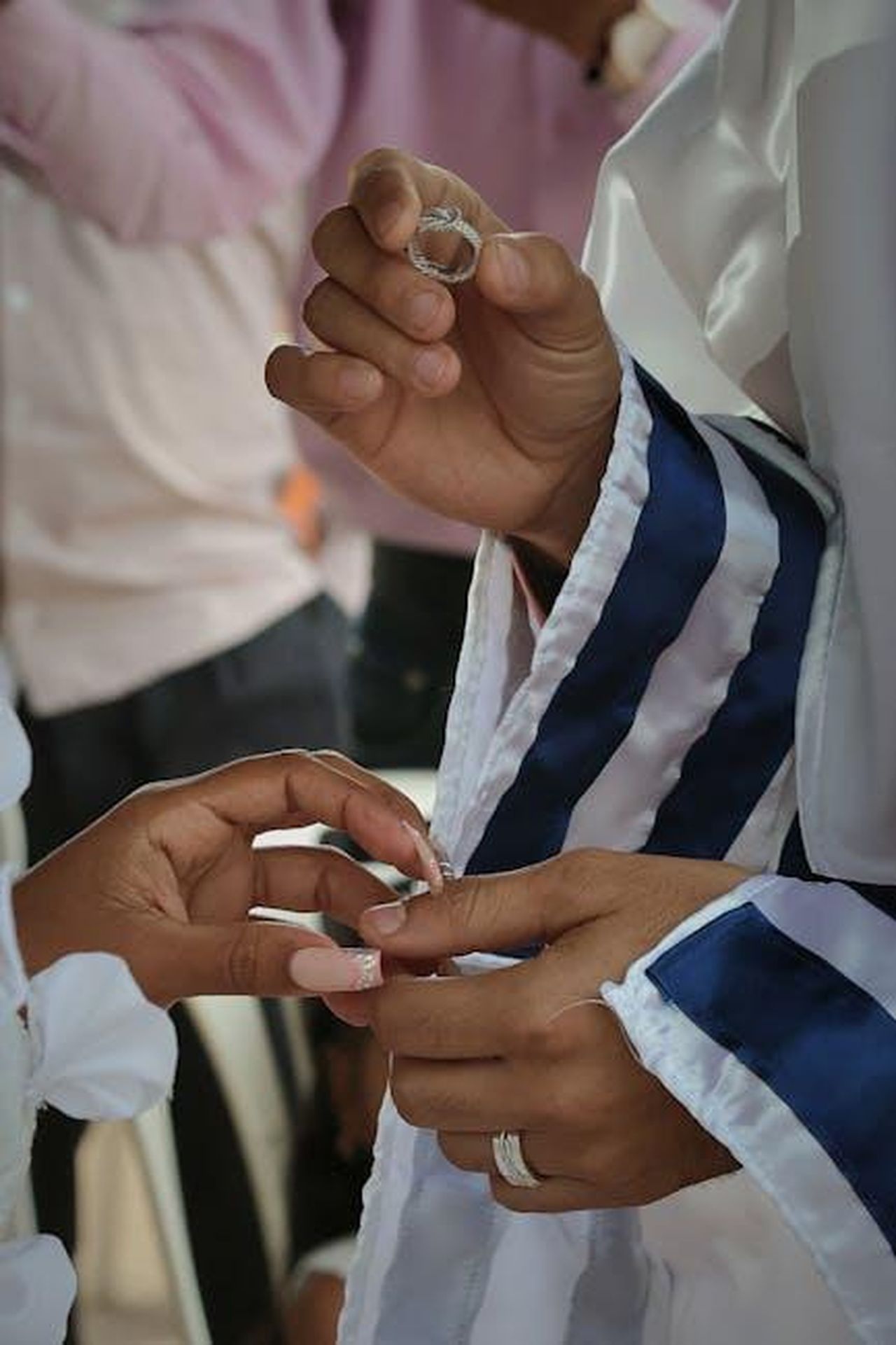 Rumori_e_relazioni_passate_aZ65HJIQZ5 - Confidenze24 Source: Ixo Diseño y Publicidad - pexels - Close-up of hands exchanging rings in a Jewish wedding ceremony.