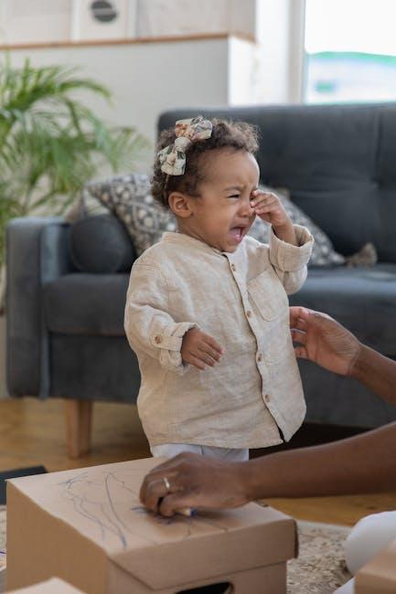 Trucchi_per_gestire_i_capricci_Mdz3vSAxMF - Confidenze24 Source: KATRIN BOLOVTSOVA - pexels - A young child crying in a living room with comforting surroundings, depicting emotion and family life.